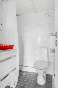 La salle de bains blanche est pourvue d'une douche et de toilettes. dans l'établissement First Camp Hagön-Halmstad, à Halmstad