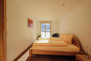 Schlafzimmer mit einem Bett und einem Fenster in der Unterkunft Châlet Bärgfride in Kandersteg