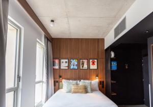 1 dormitorio con 1 cama con cabecero de madera en JOST Hotel Montpellier Centre St Roch, en Montpellier