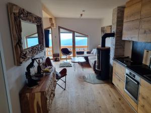 a kitchen and living room with a view of the ocean at Nockalm Appartement Hochrindl 
