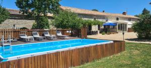 - une piscine dans un jardin avec une clôture en bois dans l'établissement Gites Chouette, à Bouin