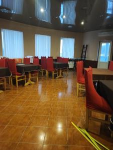 a dining room with red chairs and tables at Мотель ОК in Shepetivka