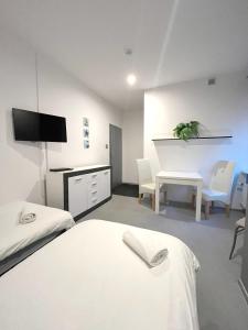 a room with two beds and a desk and a tv at Keja Aparts - 05 Gdynia Centrum in Gdynia