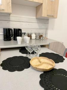 a kitchen with a table with wine glasses and rugs at Keja Aparts - 05 Gdynia Centrum in Gdynia