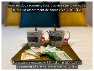 dos tazas de café sentadas en una mesa en una habitación de hotel en Maison Hyper Centre d’Arras, en Arras