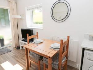 a dining room with a table and a mirror at North View Cottage next to Hadrian's Wall in Gilsland