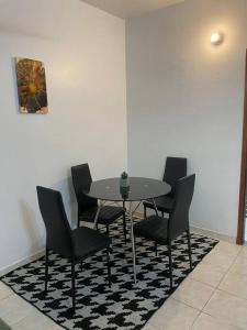 una mesa y sillas sobre una alfombra blanca y negra en Hermoso Departamento con Balcón!, en Asunción