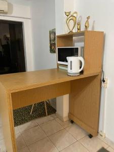 escritorio de madera con microondas y ordenador. en Hermoso Departamento con Balcón!, en Asunción