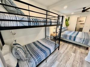 two bunk beds in a room with a mirror at Sleeps 22, 7 bedrooms, 2min walk To The Beach, Private Heated Pool and Hot Tub, Zula Del Mar South Padre Island Texas in South Padre Island