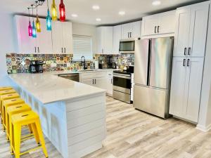 a kitchen with white cabinets and a white refrigerator at Sleeps 22, 7 bedrooms, 2min walk To The Beach, Private Heated Pool and Hot Tub, Zula Del Mar South Padre Island Texas in South Padre Island