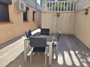 stół i krzesła na patio z balkonem w obiekcie Chambre d'hôte à la villa René w mieście Saint-Génis