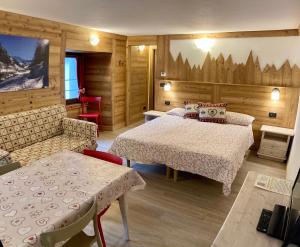 pokój hotelowy z 2 łóżkami, stołem i krzesłami w obiekcie Résidence Château Royal w mieście Cogne