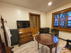 ein Wohnzimmer mit einem Tisch und einem TV in der Unterkunft Pas Birute in Kaunas