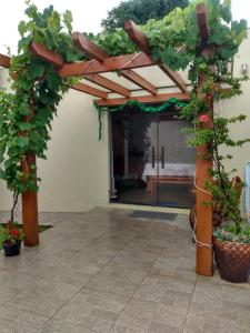 un pergolato con piante in un cortile di Casa Aconchegante ou Suítes Privativas a Canela