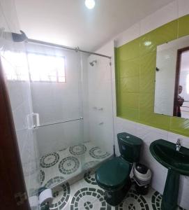 baño con aseo verde y lavamanos en Agradable Casa Familiar con parqueadero privado, en Paipa
