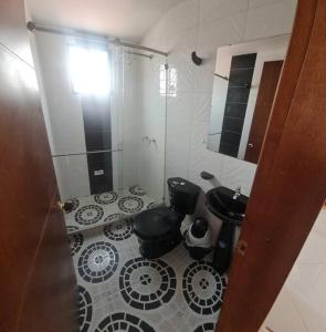 baño con ducha, 2 aseos y espejo en Agradable Casa Familiar con parqueadero privado, en Paipa