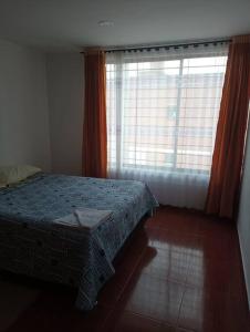 1 dormitorio con cama y ventana grande en Agradable Casa Familiar con parqueadero privado, en Paipa
