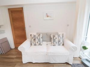 a white living room with a white couch at North View Cottage next to Hadrian's Wall in Gilsland