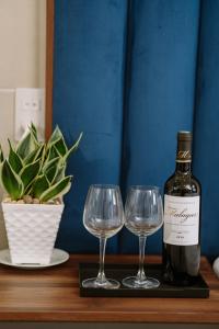 a bottle of wine and two wine glasses on a table at VÂN TRANG GARDEN HOTEL 2 in Vĩnh Long