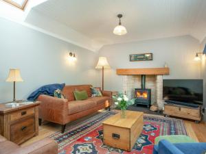 a living room with a couch and a fireplace at Wheelwright Cottage in Branscombe