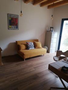 a living room with a couch and wooden floors at Magnifique villa avec jacuzzi et billard in Limoux