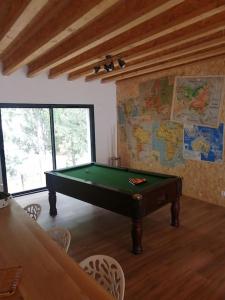 a pool table in a room with a map on the wall at Magnifique villa avec jacuzzi et billard in Limoux