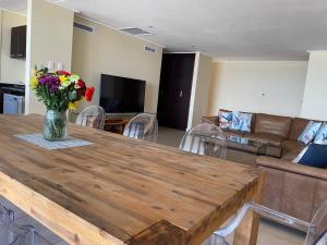 a living room with a table with a vase of flowers at UMDLOTI - On the BEACH! Private & Central. Sleeps 8. in Umdloti
