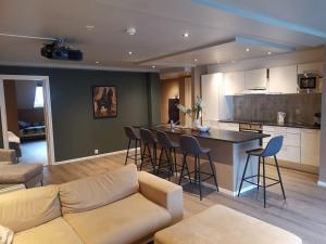 Penthouse في بيرغِن: غرفة معيشة مع أريكة ومطبخ مع بار