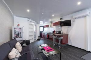 a living room with a couch and a kitchen at Charmant Studio Climatisé à Sainte Suzanne. in Commune Bègue