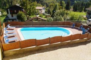a swimming pool with chairs and a fence around it at Residence ai Tovi in Ledro