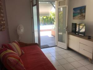 a living room with a couch and a sliding glass door at résidence Kaz'Tinou - Allo Sé Ann in Saint-François