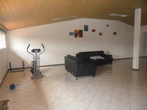 una sala de estar con un sofá negro en una habitación en Casa e Salao Coworking Botanico, en Curitiba