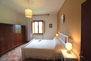 Un dormitorio con una gran cama blanca y una ventana. en CASA ANGELA, en Castiglion Fiorentino 24 fotos más