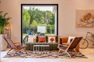 a living room with a couch and two chairs at Kimpton Aysla Mallorca by IHG in Santa Ponsa