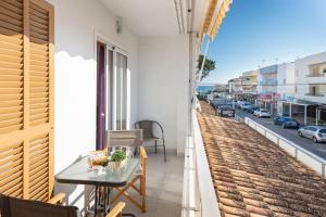a balcony with a table and a view of a street at Cimbell II in Playa de Muro