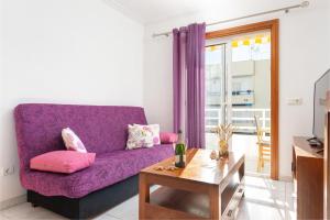 a living room with a purple couch and a table at Cimbell II in Playa de Muro