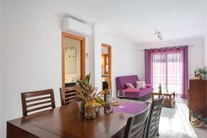 a dining room with a table and a purple couch at Cimbell II in Playa de Muro