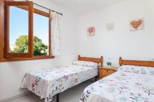 a bedroom with two beds and a window at Cimbell II in Playa de Muro