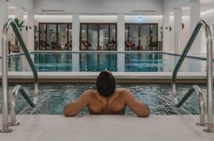 a man in a bath tub in a swimming pool at Kimpton Aysla Mallorca by IHG in Santa Ponsa
