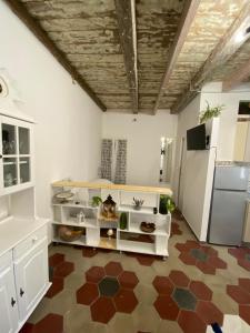 eine Küche mit weißen Schränken und braunem Boden in der Unterkunft Lu Bàtil B&B - Rooms in Alghero