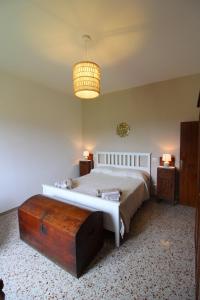 um quarto com uma cama grande e um lustre em CASA ANGELA em Castiglion Fiorentino