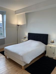 - une chambre avec un grand lit blanc et une tête de lit noire dans l'établissement Le Royal XIX Vue mer, à Dinard