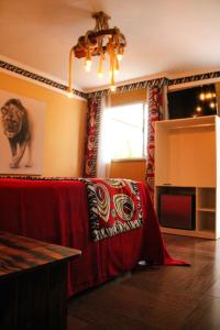 Sala de estar con cama con manta roja en Pousada No Meio do Mundo en Anchieta