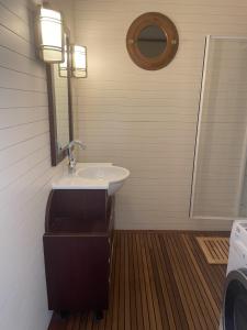 La salle de bains est pourvue d'un lavabo et d'un miroir. dans l'établissement Le Royal XIX Vue mer, à Dinard