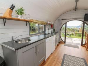 an open kitchen with a sink and an archway at Woodland View in Rhayader