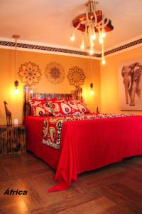 a bedroom with a bed with a red blanket at Pousada No Meio do Mundo in Anchieta