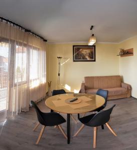 a living room with a table and chairs and a couch at Apartmani Janja in Soko Banja