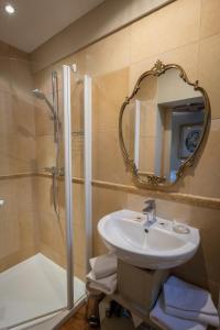 La salle de bains est pourvue d'un lavabo et d'une douche avec un miroir. dans l'établissement L'hôtel de Panette, charpente historique, à Bourges