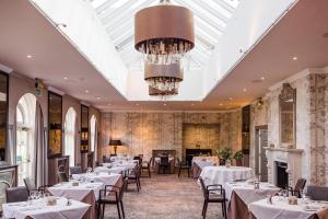 a dining room with tables and chairs and a skylight at Balbirnie House Hotel in Glenrothes