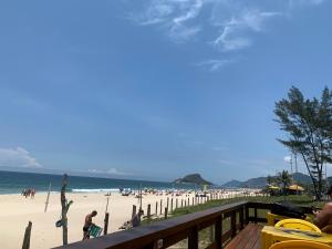 Blick auf den Strand von einer Terrasse am Strand in der Unterkunft Flat moderno e sofisticado in Rio de Janeiro